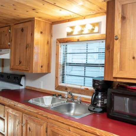 Wood kitchen with stove, microwave, coffee machine and sink