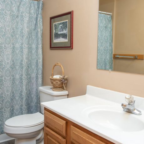 Bathroom sink, toilet, and shower curtain covering tub