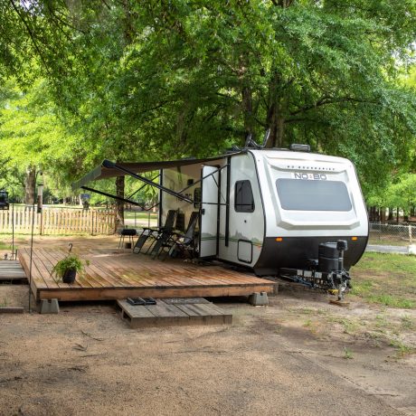 RV set up with front deck, awning and chairs