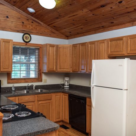 Kitchen with stove, microwave, sink, coffee machine and refrigerator