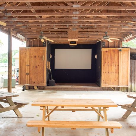 Outdoor recreation with projector screen stage and awning structure