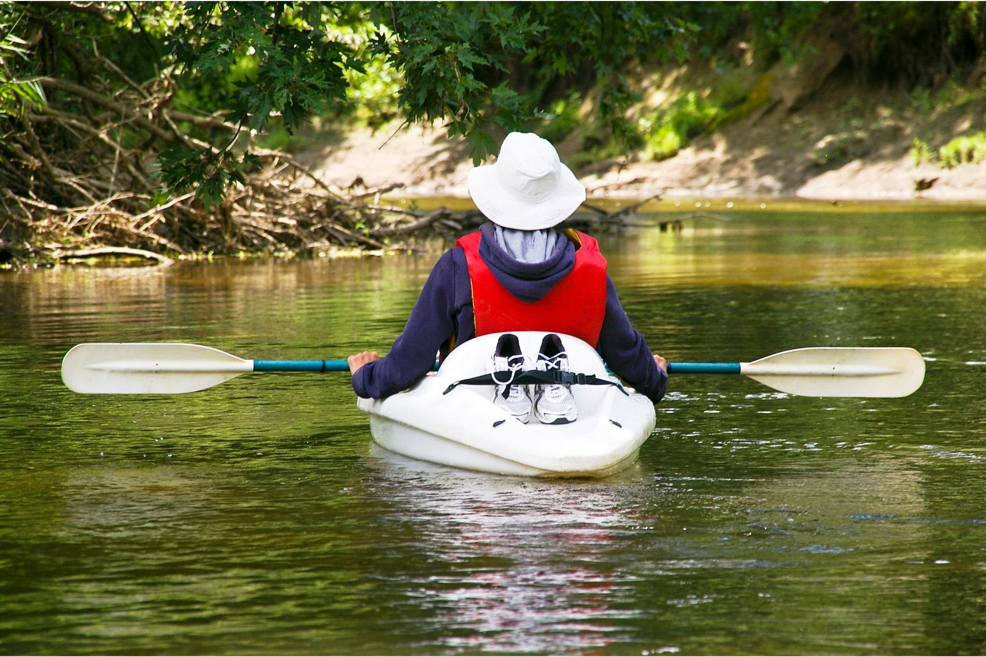 Someone on a kayak with the paddle rested on their legs